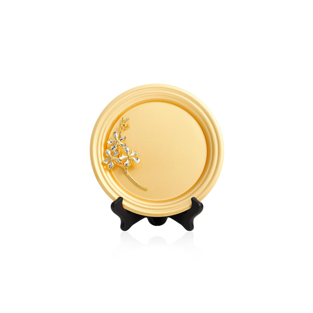 Risis Vanda Limbata Orchid Spray On 8 5 Inch Plaque - A golden round plaque with a silver and gold jeweled brooch shaped like an olive branch, displayed on a miniature black stand. The brooch sparkles with embedded gems.