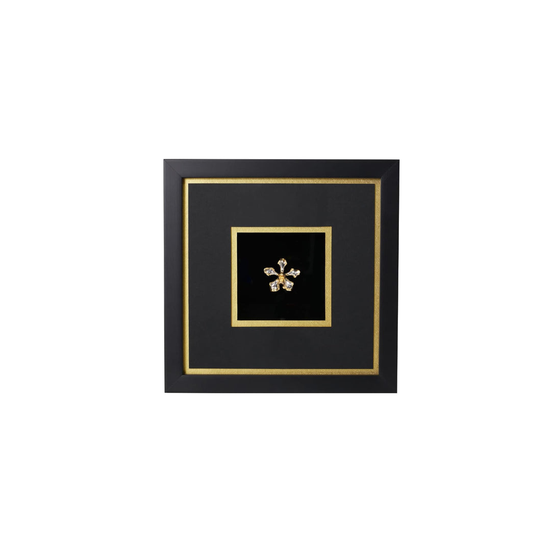 Risis Vanda Wee Kim Lian Orchid Frame IV - A golden, starburst-shaped brooch with gemstone accents is centrally displayed against a black, square backdrop framed in black with gold trim.