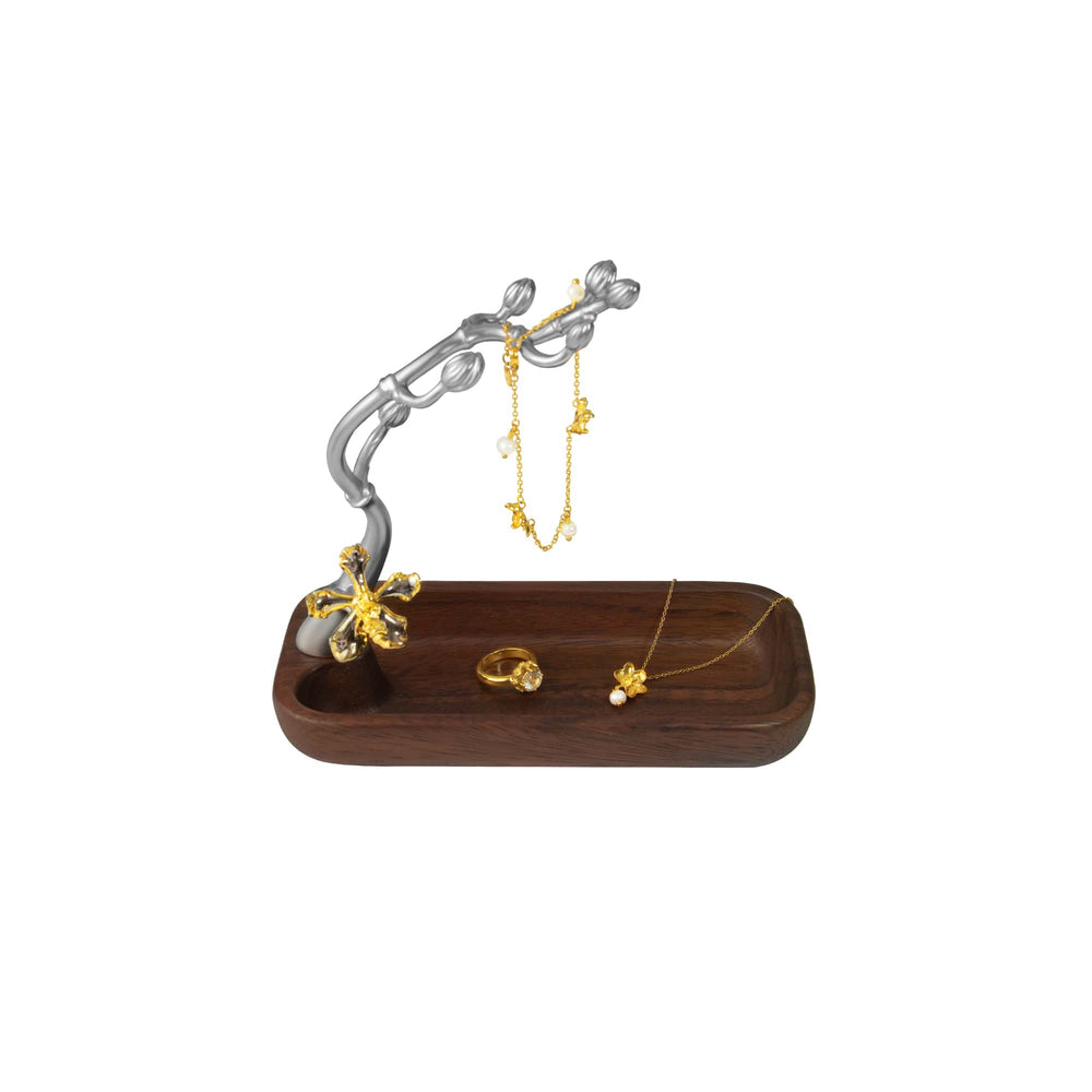 Risis Wee Kim Lian Groves Holder - A wooden jewelry tray holds gold-tone pieces with floral motifs; a matching metallic tree-like stand displays hanging earrings.