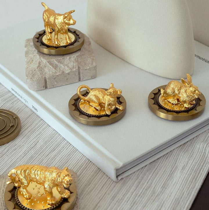 Risis 12 Constellation Base (Cancer) - Golden animal figurines—rabbit, bull, and bear—rest on circular metallic bases with intricate edgings, displayed as luxurious decorative objects.