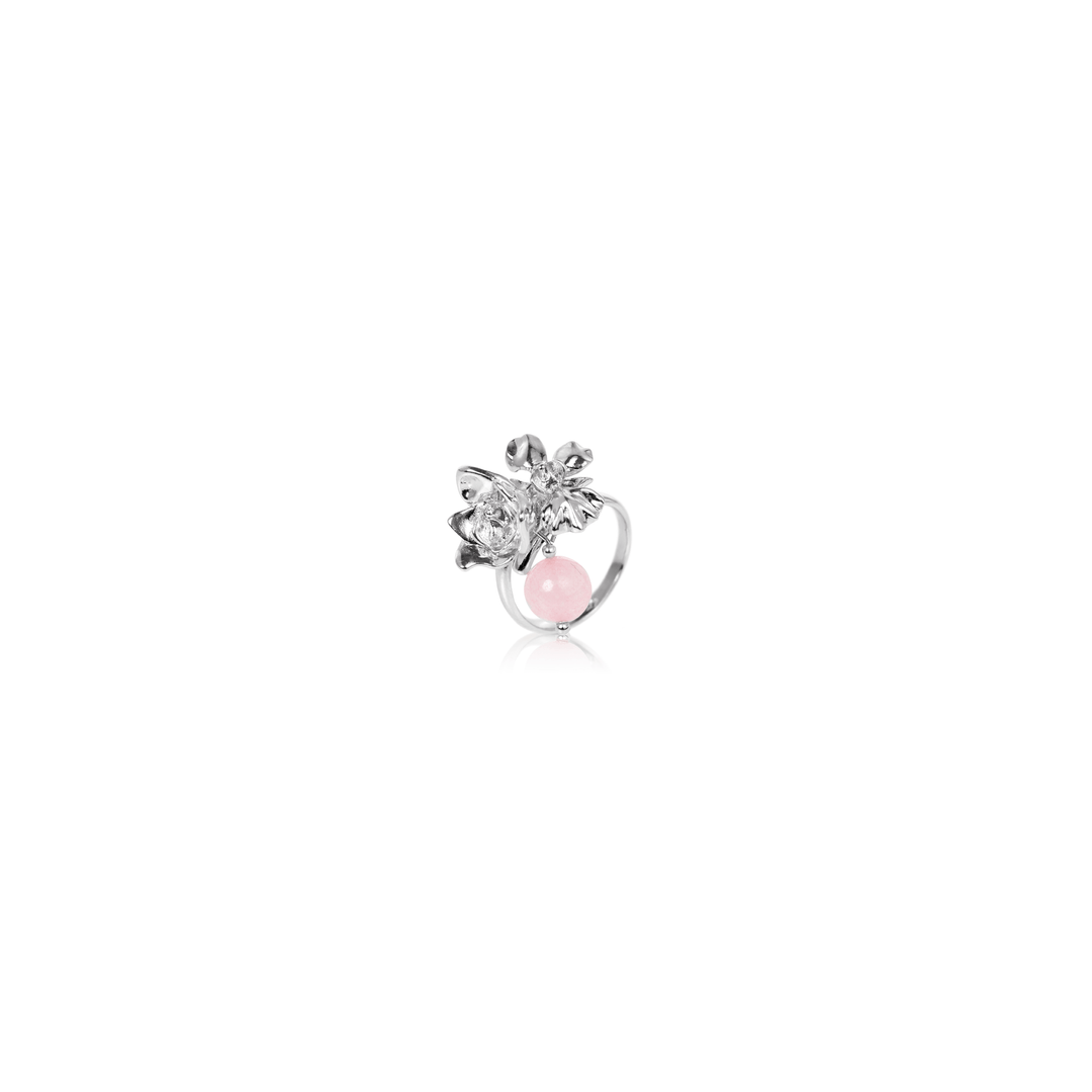 Risis Budding Love Ring with Rose Quartz - A silver ring features a pink oval gemstone at its center, flanked by metal leaves and floral details, creating an elegant and feminine piece of jewelry.