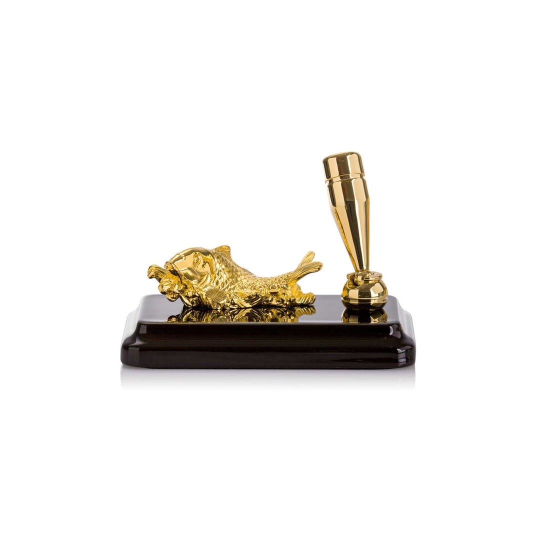 Risis Carp Rest Pen Holder - A golden, glossy lion figurine lies beside a matching sleek pen, both resting on a polished, black base, exuding elegance and luxury.