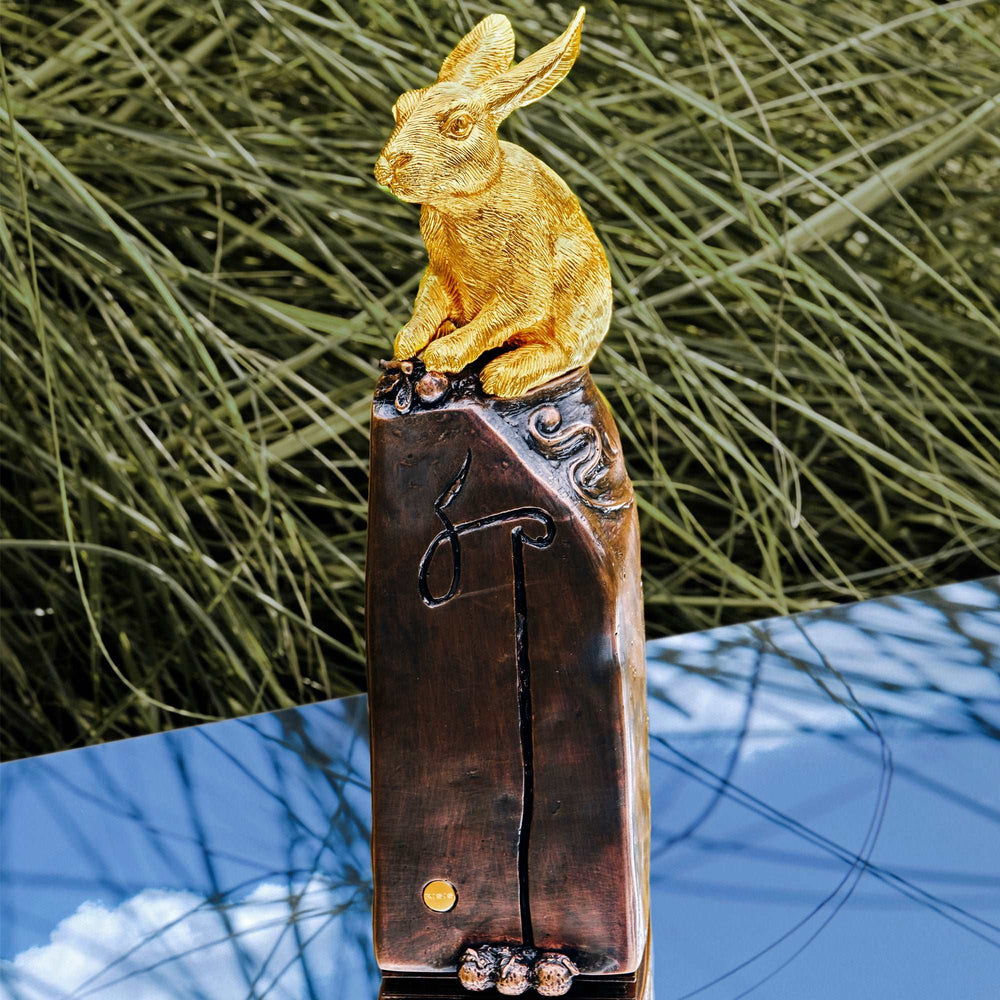 Risis Celestial Seal - A golden rabbit sculpture with textured fur sits atop a dark metallic base with ornate carvings and bronze-colored accents.
