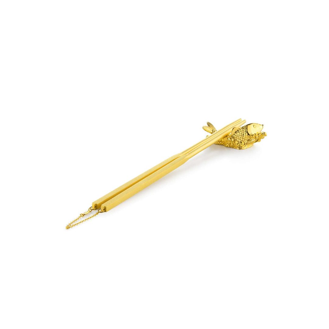 Risis Chopsticks with Carp Rest - A golden hairpin featuring a detailed fish at one end, with texture suggesting scales, and a fine chain attached to the tail. The item evokes elegance and craftsmanship.