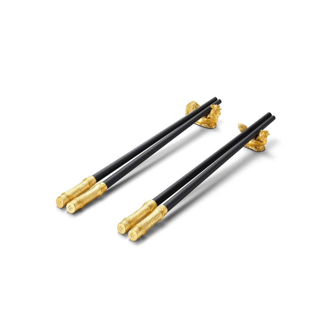Risis Chopsticks with Rooster and Hen Rests - A set of three sleek black chopsticks with ornate golden ends, lying parallel on a light surface, conveying elegance and artistic craftsmanship.