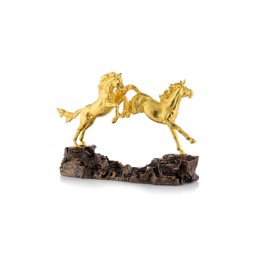 Risis Concord Horse - Two golden horses, mid-rear, on a rugged, dark base, portraying movement and elegance against a plain background.