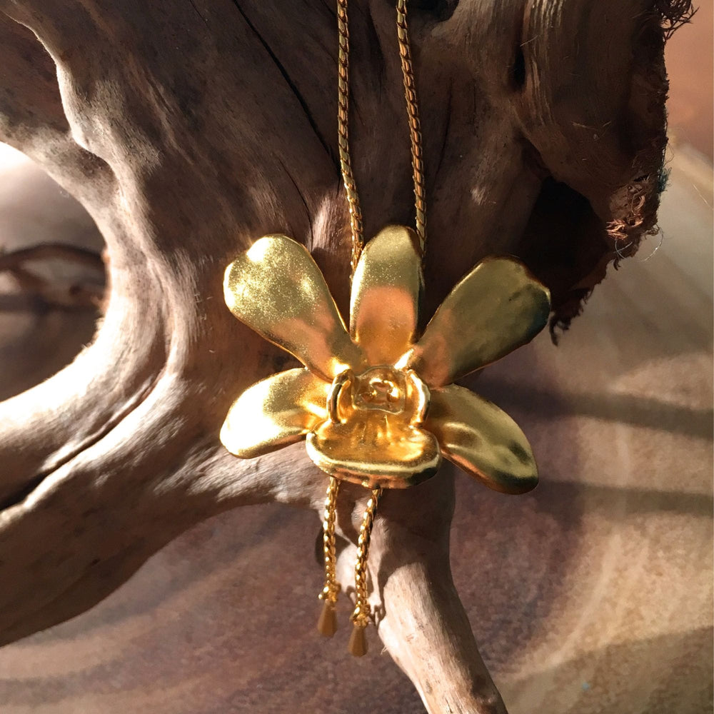 Risis Dendrobium Thong Chai Orchid Slider Necklace (G) - A golden flower-shaped pendant with a lustrous finish and delicate dangling chains glimmers with warmth and elegance.