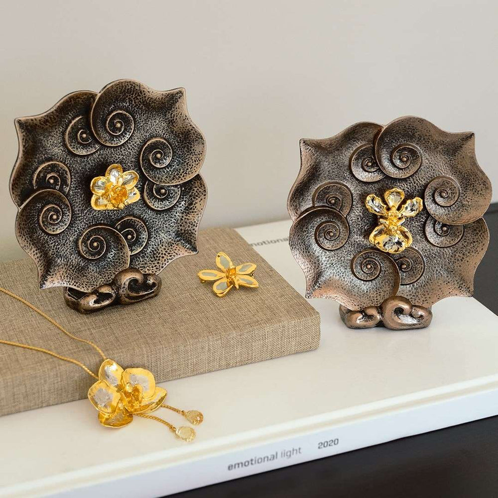 Risis Doritaenopsis Purple Gem Ruyi Plate - Two decorative metallic plates with embossed spiral patterns and central golden flowers, accompanied by a matching butterfly jewelry piece and a flower pendant necklace.