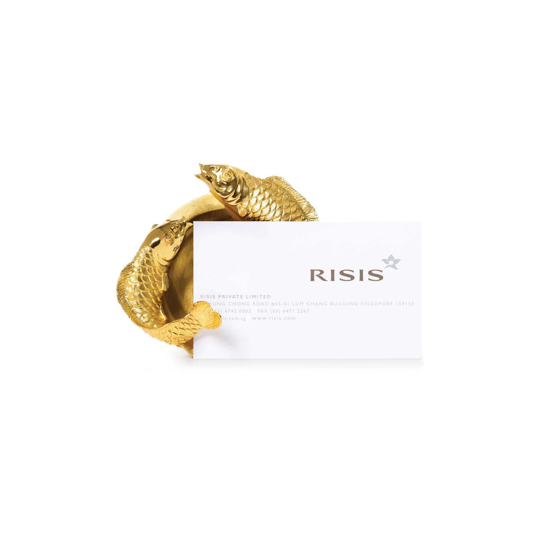 Risis Dual Carp Name Card Holder - A golden bangle shaped like two fish, with intricately detailed scales, encircles a white card with black text and a floral emblem.