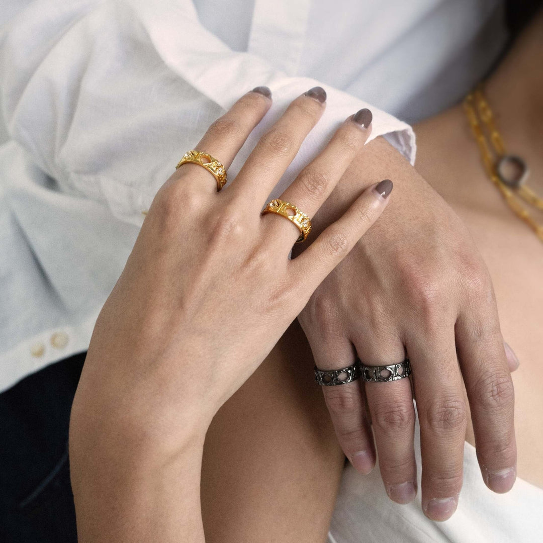 Risis Entwined Rattan Ring (BRH) - A golden band ring with intricate cut-out design and small diamonds nestled within, elegantly combining luxury with artistic craftsmanship.