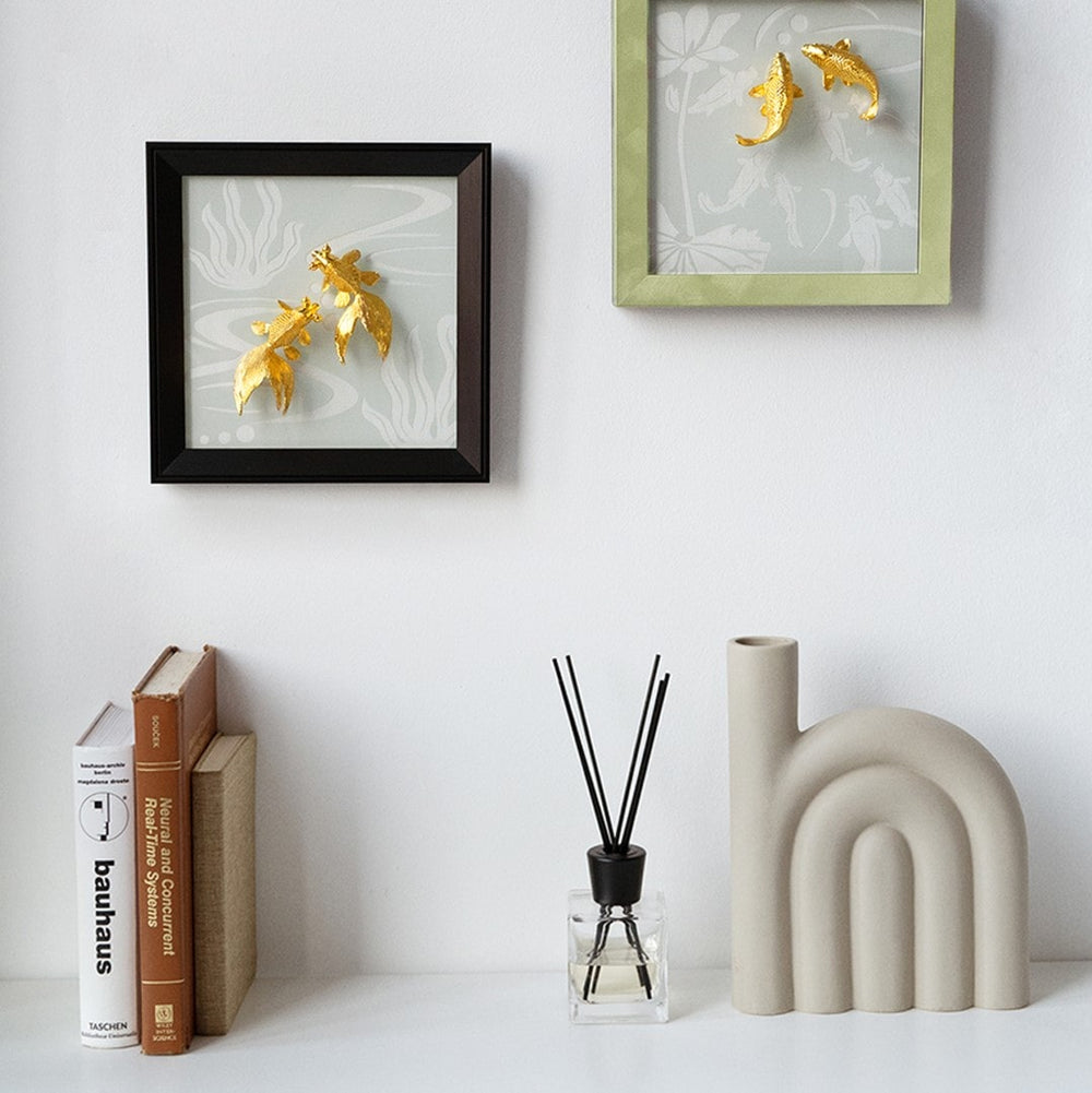 Risis Goldfish Frame III - Two framed artworks display shimmering gold leaf fish against a patterned background. The pieces exude a modern, decorative elegance.