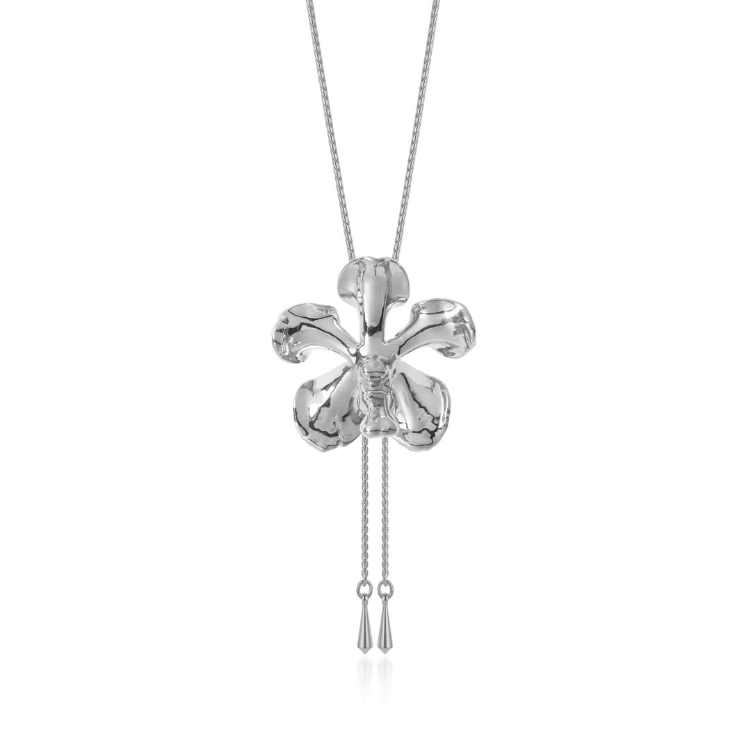 Risis Kagawara Firebird Orchid Slider Necklace (P) - A silver, four-leaf clover pendant on a fine chain, with a glossy finish and two dangling tassels beneath, embodying elegance and simplicity.