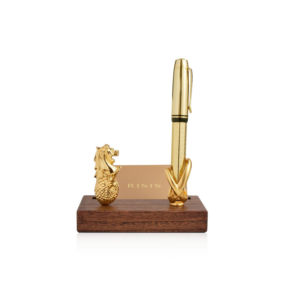Risis Merlion Infinity Pen And Name Card Holder - A golden pen stands alongside a miniature dragon sculpture on a dark wooden base, with a gilded rectangular plaque between them.