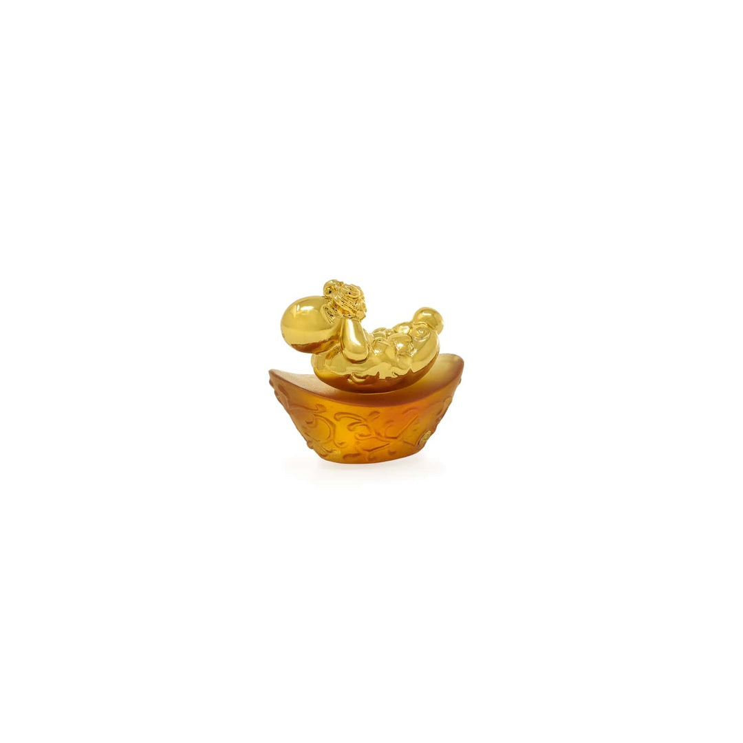 Risis Mini Celestial – Goat on Amber Liu Li - A golden figurine lies in a textured amber-colored dish; the figure's details and glossy sheen suggest a decorative purpose.