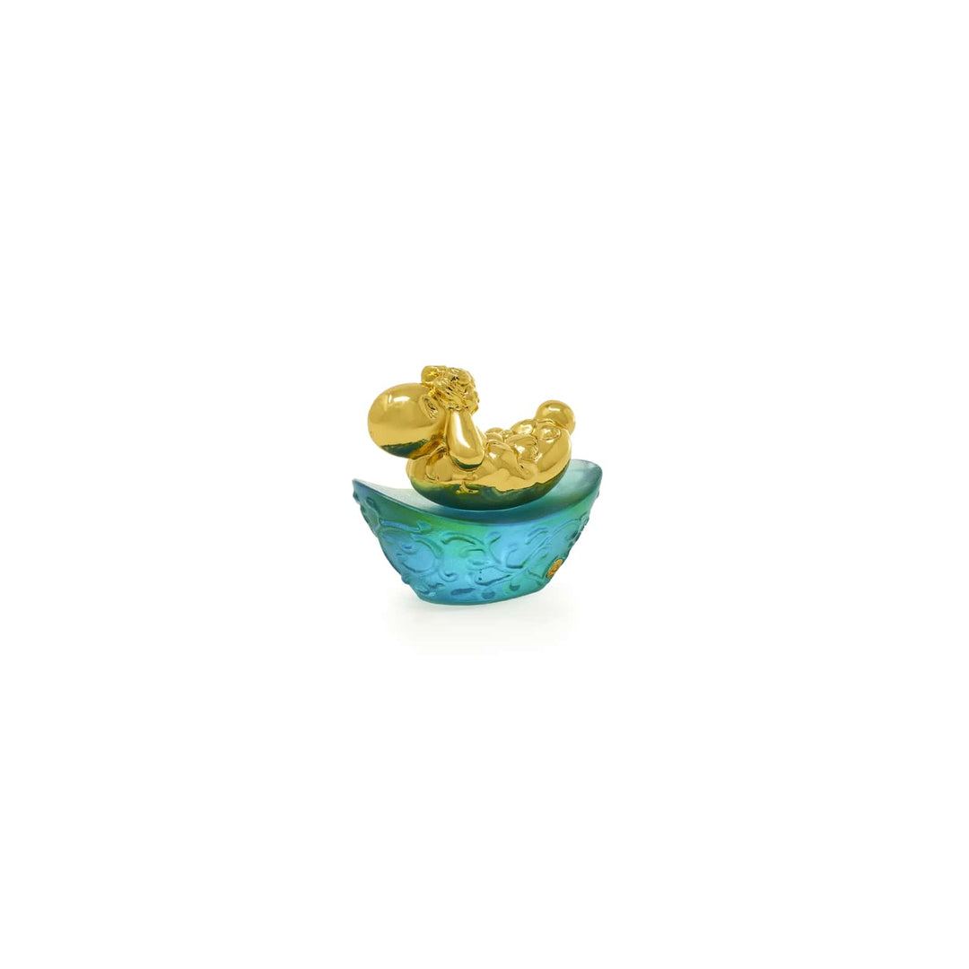 Risis Mini Celestial – Goat on Green Liu Li - A shiny, golden-finished reclining figure with a relaxed expression rests inside a textured, teal-colored bowl with a petal-like edge.