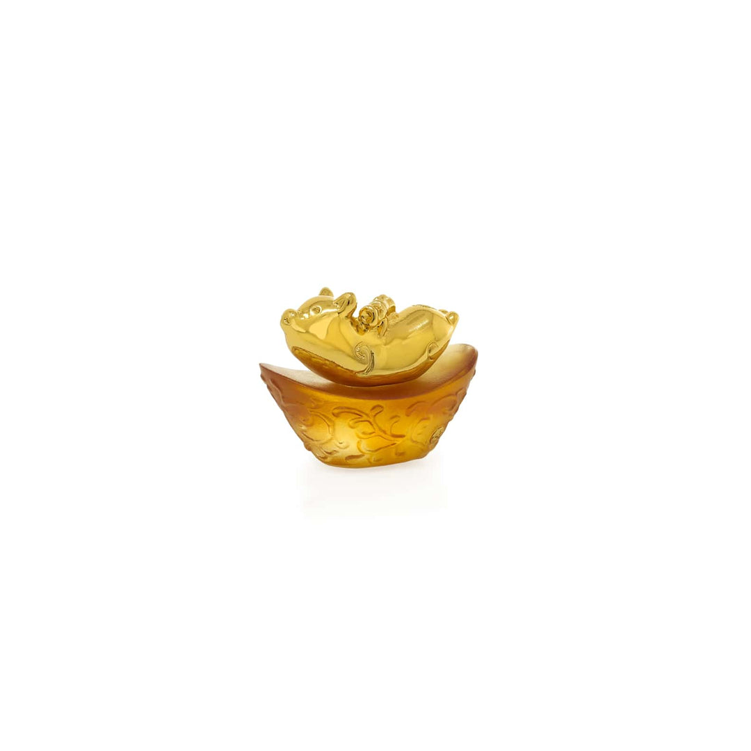 Risis Mini Celestial – Pig on Amber Liu Li - A golden decorative object resembling an ornate, stylized lotus flower, with detailed petal patterns and a gradient transition from a darker base to a lighter top.