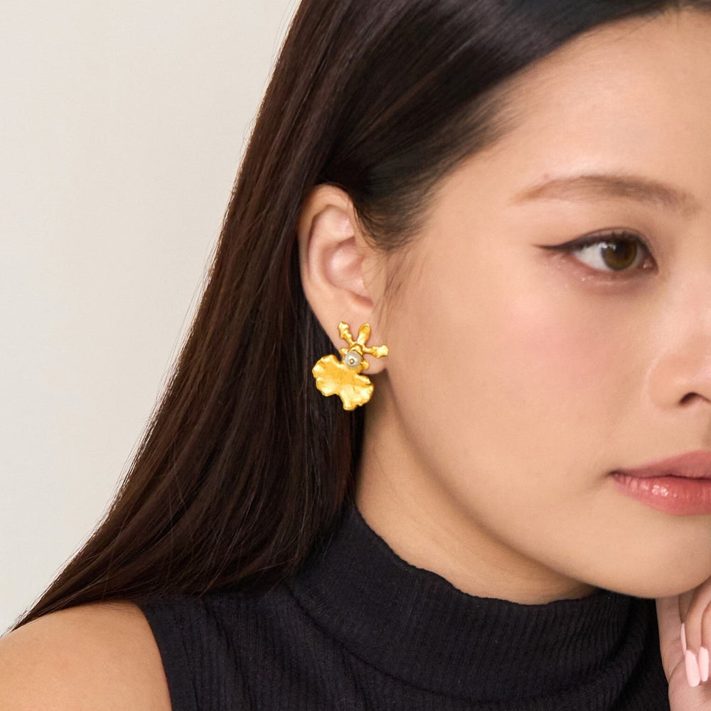 Risis Oncidium Shower Earrings (G) - A golden earring with an intricate floral design is displayed on a person's ear, imparting an artistic and elegant appearance.