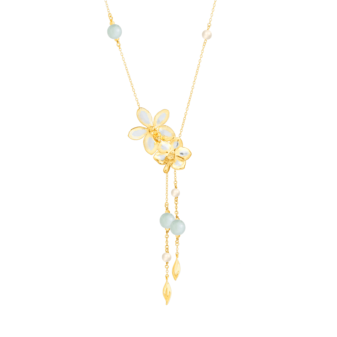 Risis Orchid Meadows Necklace with Jade and Pearl - A delicate gold necklace featuring a central floral motif with white petals, offset with pale blue and white beads, and accented with dangling leaf-shaped pendants.