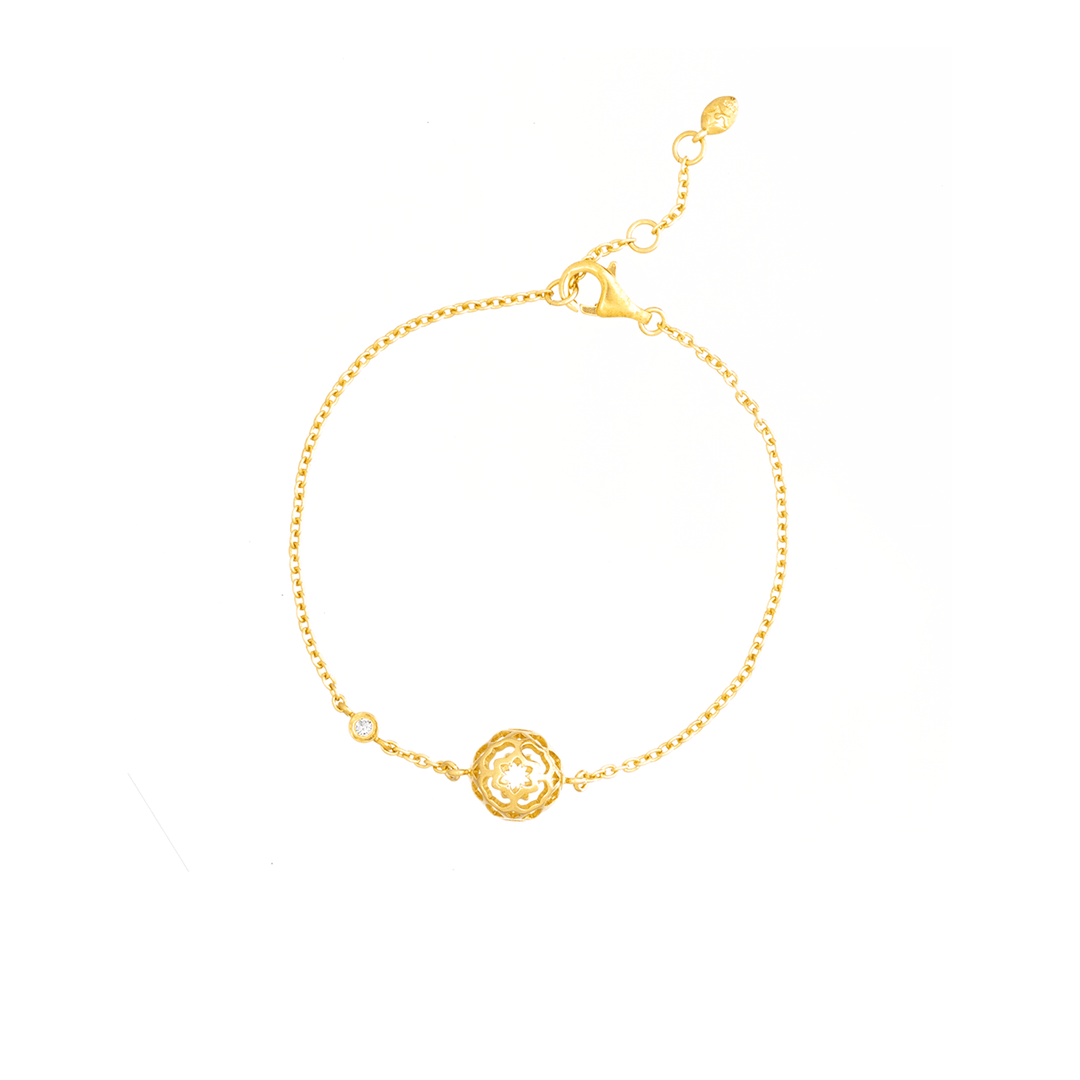 Risis Peranakan Spheres Bracelet with White Topaz (G) - A delicate gold bracelet features a central intricate filigree design with a small gemstone, exuding elegance and craftsmanship.
