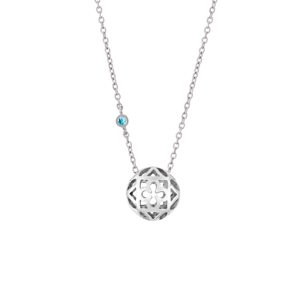 Risis Peranakan Spheres Large Necklace with Blue Topaz (RH) - A silver pendant with intricate cut-out detailing hangs on a delicate chain, accented by a small, blue gemstone closer to the clasp.