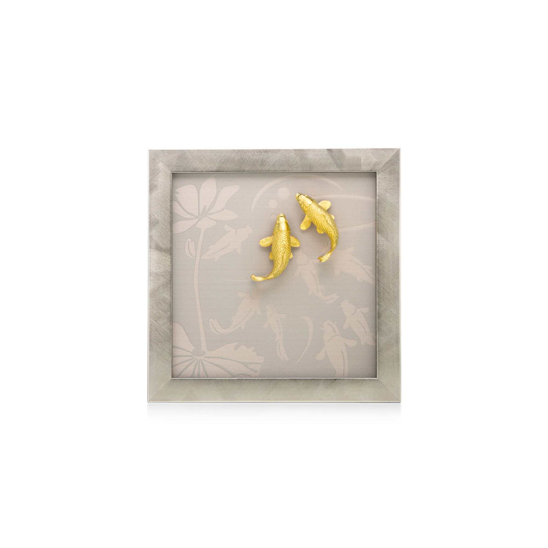 Risis Nine Carp On Frame - A pair of golden, textured alligator-shaped earrings is presented on a neutral-toned fabric with subtle floral patterns, framed for artistic display.
