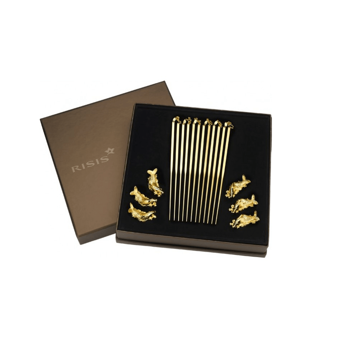 Risis Set of 6 Gold-Plated Chopsticks with Carp Rest - Eleven slender gold rods and five miniature gold sculptures are symmetrically arranged inside an elegant black presentation box with a metallic brand logo.