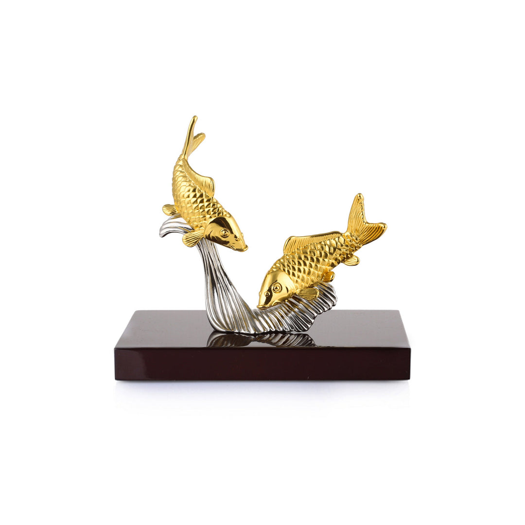 Risis Two Carps On Wave - Two golden fish sculptures with textured scales are attached to curving silver waves, poised on a rectangular base. The craftsmanship conveys movement and elegance.