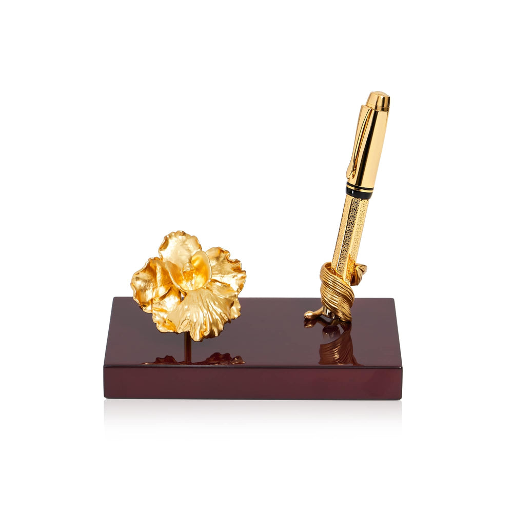 Risis Vanda Miss Joaquim Orchid and Leaf Pen Holder - A golden pen secured by a twisted holder and a gold-toned flower rest on a glossy rectangular base, displaying elegance and craftsmanship.
