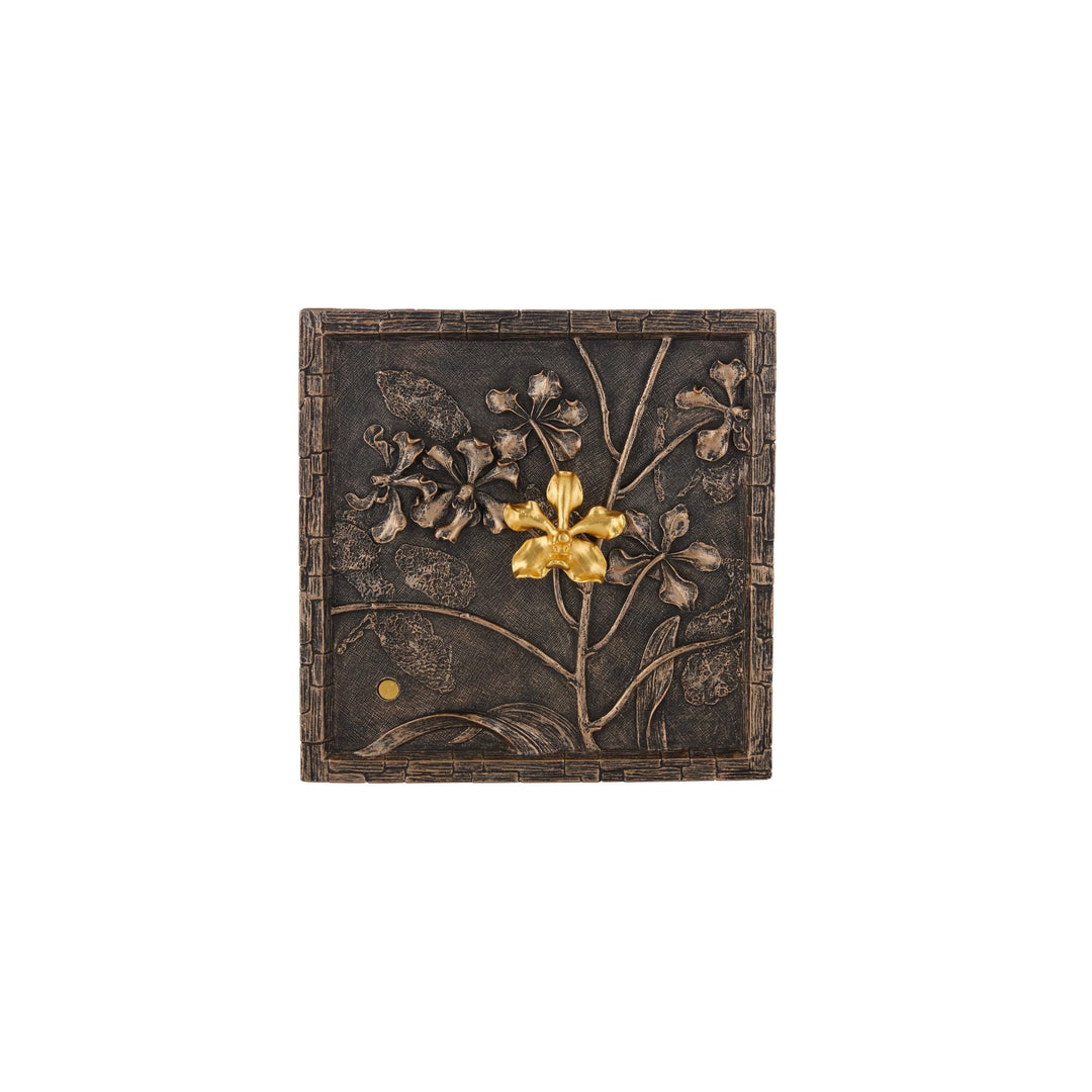 Risis Vanda Orchid Bronze Frame (S) - A square, textured object features intricately carved flowers and leaves, with a single gold flower as the centerpiece, creating a contrast against the darker background.