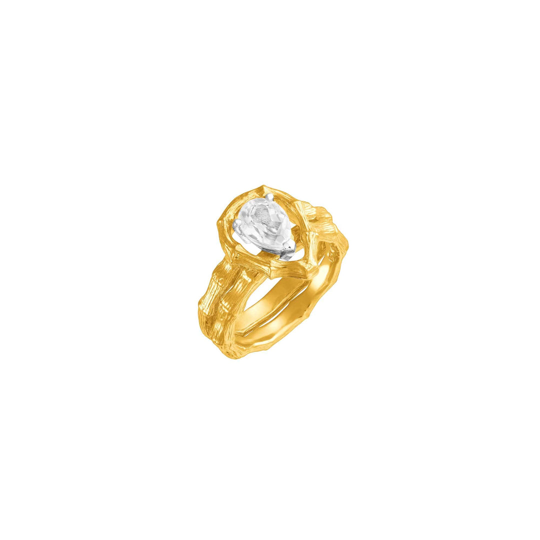 Risis Vintage Bamboo Ring with White Topaz - A gold ring with textured bands culminates in a large, central, oval-cut gemstone, displaying its intricate faceting and brilliant shine.